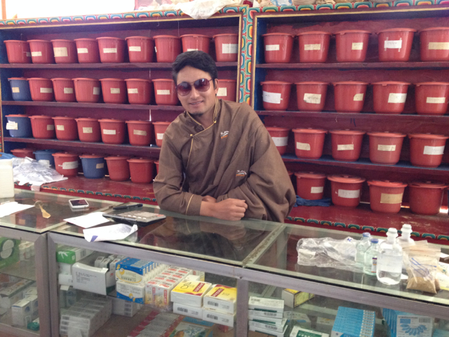 Dr. Ngawang Phuntso dispenses Tibetan and Western medicines from the clinic pharmacy.