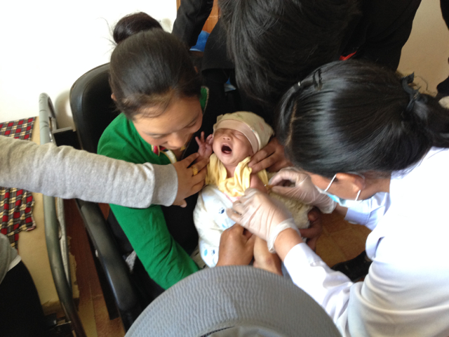 Midwife vaccinates newborn in the clinic